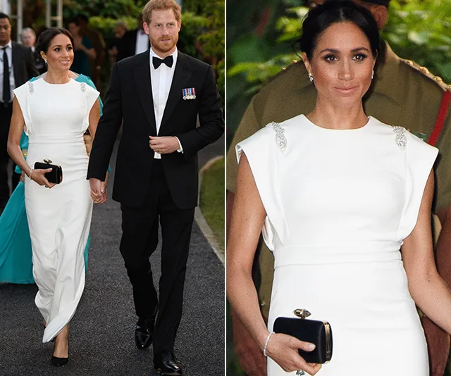Meghan in a white dress holding hands with Prince Harry in a tuxedo during a formal event.