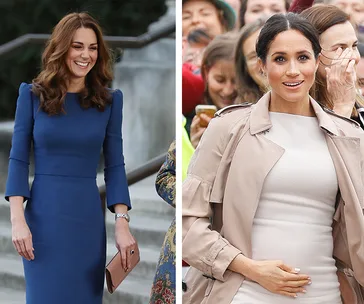 Two women, one in a blue dress holding a clutch, the other in a beige coat, among a crowd.