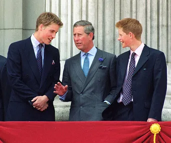 Three men in suits standing on a balcony, engaged in conversation.