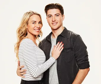 A smiling couple poses together, the woman in a striped shirt and the man in a dark jacket.