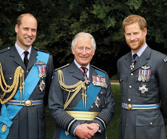 Three men in military uniforms with medals, standing outdoors and smiling.