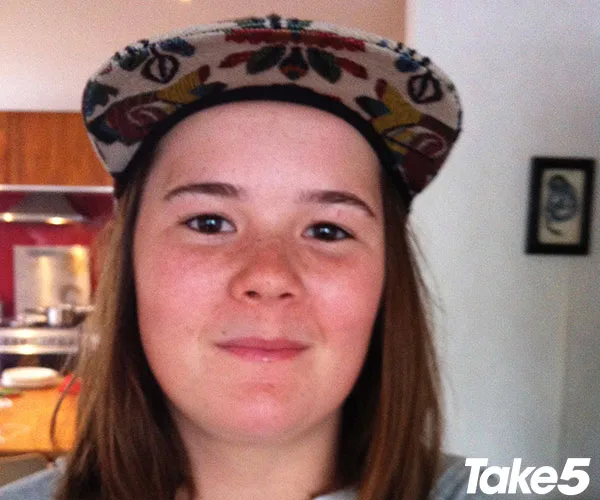 A person wearing a patterned cap, smiling in a kitchen setting with Take5 logo in the corner.
