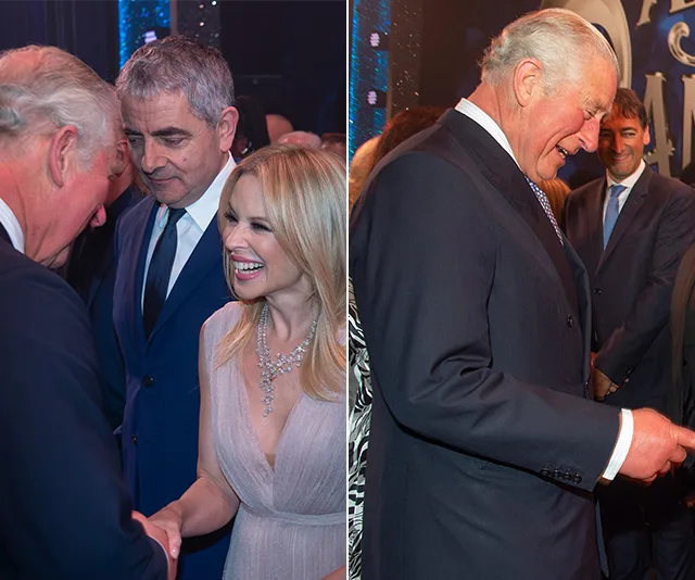 People socializing at an event; a woman smiling and greeting a man in a suit.