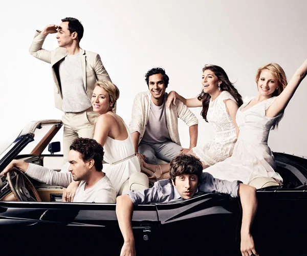 Cast of "The Big Bang Theory" posing in and around a convertible car, looking joyful and celebratory.