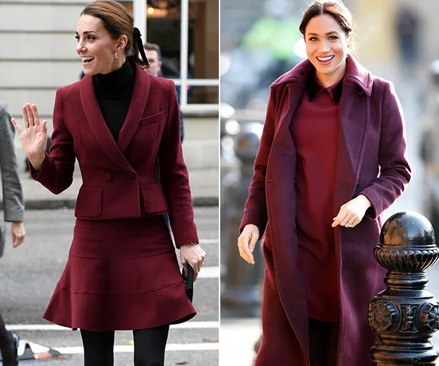 Two women in red outfits, one waving in a suit, the other smiling in a dress and coat.
