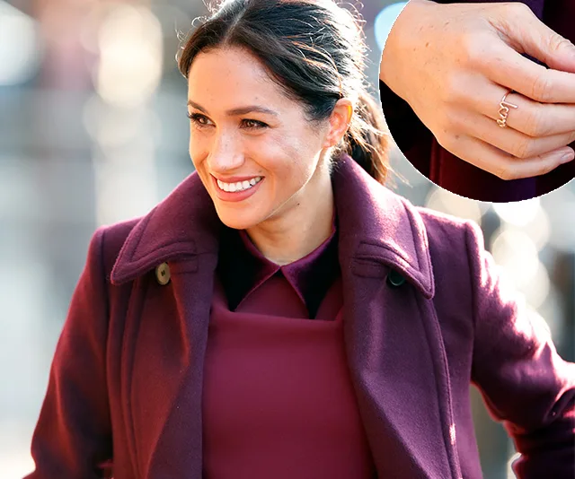 Meghan Markle smiling in a burgundy coat, inset of her hand showing a delicate gold ring.