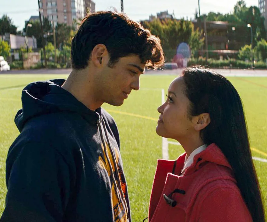 Two characters from "To All the Boys I've Loved Before" share a tender moment on a soccer field.