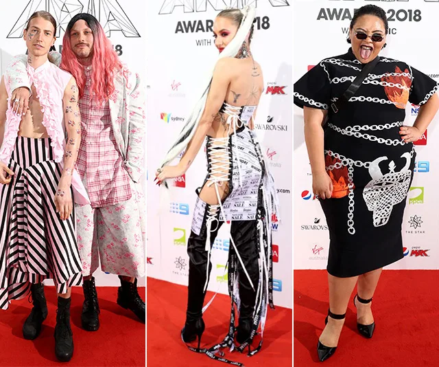 Three people in colorful, eclectic outfits pose on the red carpet at the ARIA Awards 2018.