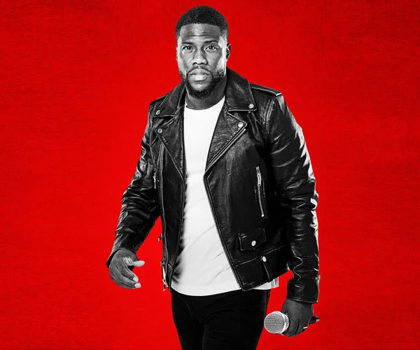 Man in black leather jacket with microphone on a red background.