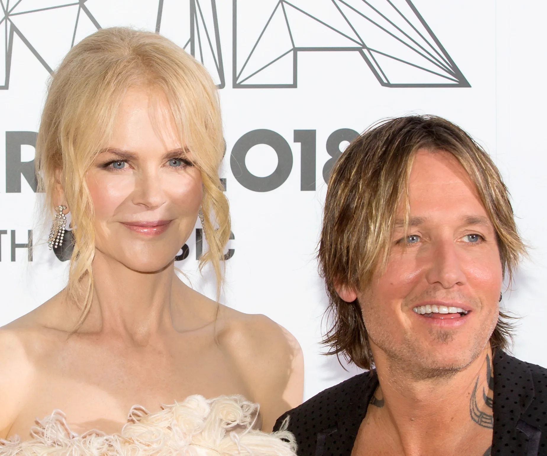 Nicole Kidman and Keith Urban smiling at an event, wearing formal attire.