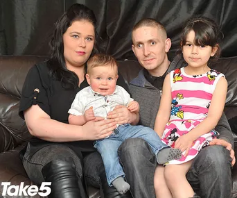 Family sitting on a sofa, holding a baby and young child, with "Take 5" logo in the corner.