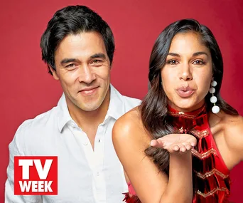 Two people smiling and posing for a TV Week Christmas shoot, one blowing a kiss, both wearing festive attire.