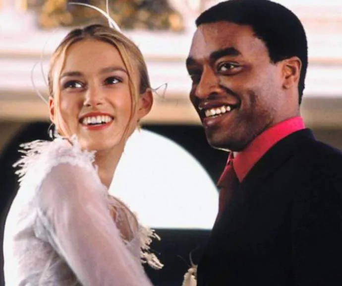 A happy couple smiling, dressed for a formal occasion.