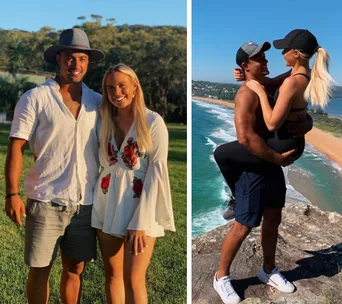 Couple smiling outdoors and woman lifted by man on a cliff overlooking the ocean.