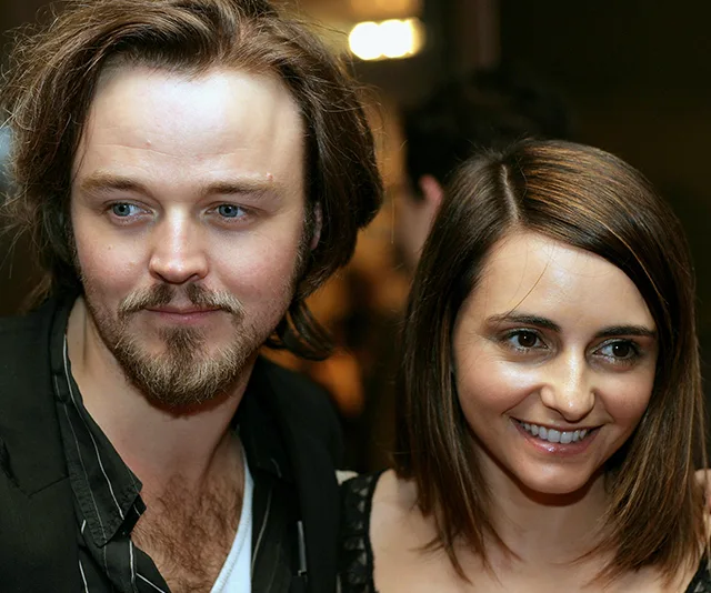 Two smiling individuals, posed closely together at an event.