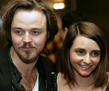 Two smiling individuals, posed closely together at an event.