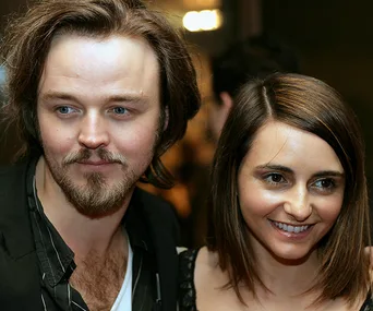 Two smiling individuals, posed closely together at an event.