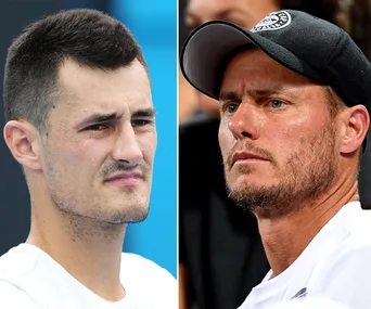 Two tennis players, one wearing a white shirt, the other in a cap, both with focused expressions on their faces.