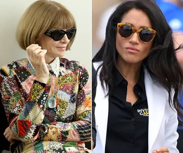 Two women wearing sunglasses; one in a colorful dress with a bob haircut, the other in a black shirt and white jacket.
