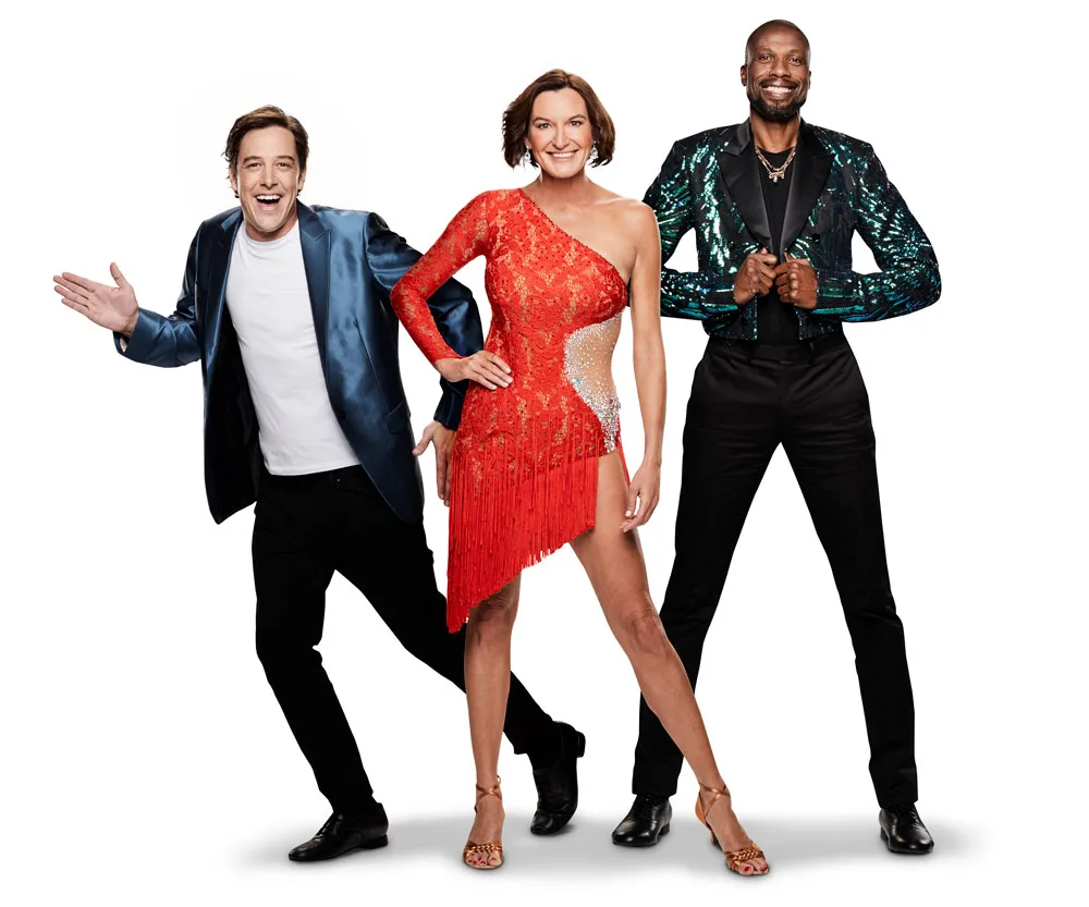 Three people posing; man in blue jacket, woman in red fringe dress, man in sequined jacket. "Dancing with the Stars" 2019.