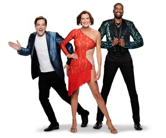 Three people posing; man in blue jacket, woman in red fringe dress, man in sequined jacket. "Dancing with the Stars" 2019.