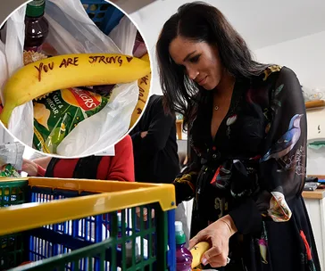 A woman writes "You are strong" on a banana at a charitable event.