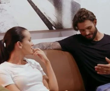 A couple on a couch engaged in conversation, from "Married at First Sight" scene.