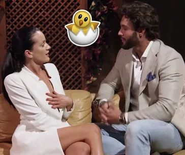 A man and woman in formal attire sit on a couch talking; a cartoon chick in an egg overlays the image.