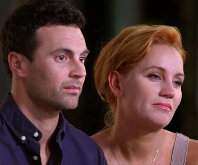 A couple from "Married at First Sight" sitting closely, looking concerned or reflective.