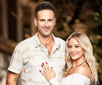 A couple from "Married at First Sight" smiling, woman with blonde hair touching the man's shoulder.