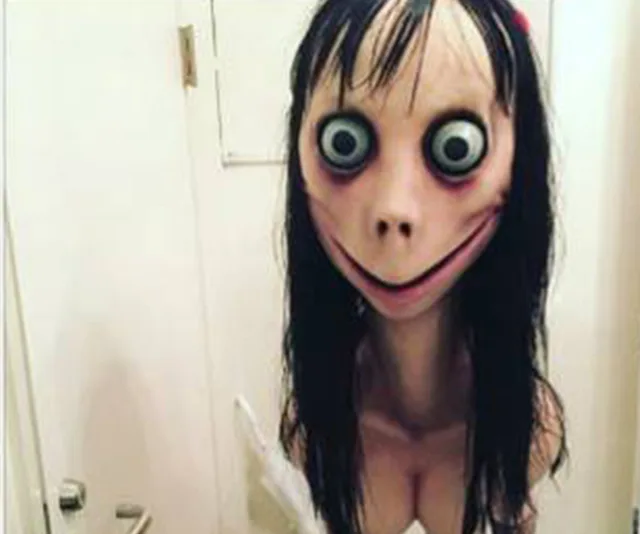 A creepy sculpture with a wide smile, large eyes, and long black hair, known as the "Momo" internet urban legend.