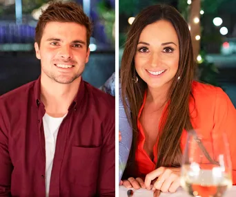Two people smiling at a dining setting, a man in a maroon shirt and a woman in a red blouse, with a wine glass.