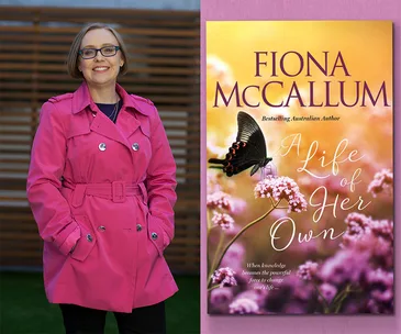A woman in a pink coat smiles next to the cover of "A Life of Her Own" by Fiona McCallum, featuring a butterfly on flowers.
