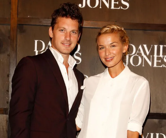 A couple posing together at a formal event, with a "David Jones" backdrop behind them.