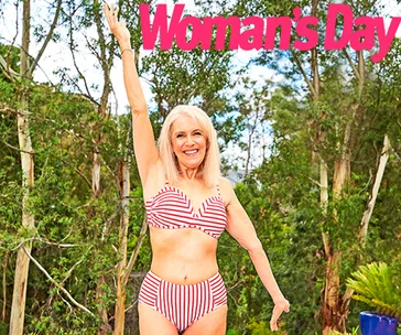 Senior woman in a red and white striped bikini raising one arm, outdoors with trees in the background, "Woman's Day" text above.