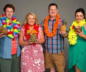 Four people in Hawaiian attire holding tropical drinks, smiling against a plain background.