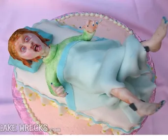 A cake depicting a girl with red hair in a bed, face appears distressed; styled after horror film character Regan MacNeil.