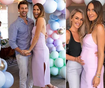A pregnant woman in a lilac dress at a baby shower with balloons, posing with a man and another woman.