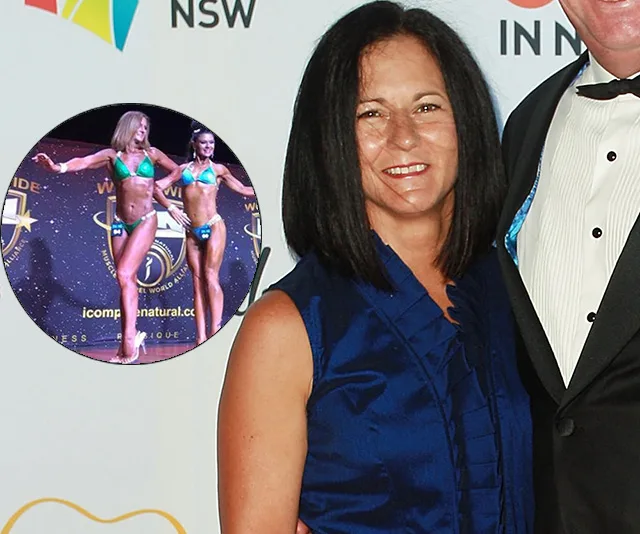Woman in blue dress smiles beside a suited person, with inset of two female bodybuilders in green bikinis on stage.