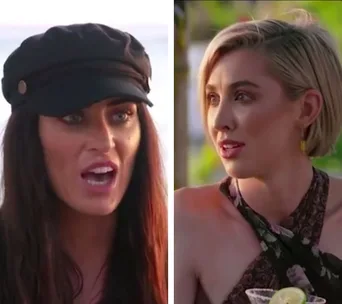 Two women in a conversation; one wearing a black cap, the other with short blonde hair, dressed in a floral top.