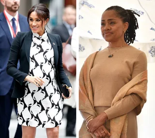 Two women, left in black and white dress smiling, right in brown outfit, standing and looking ahead.