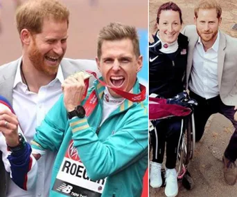 Prince Harry with marathon participants celebrating, one in a wheelchair holding a medal.