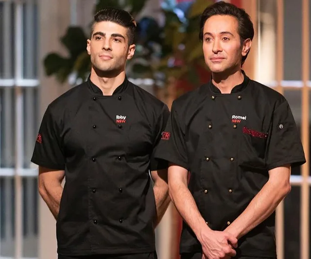 Two chefs in black uniforms, standing side by side, with names embroidered: Ibby and Romel.
