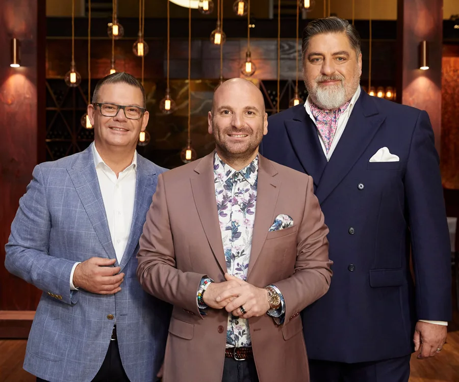 Three judges from MasterChef Australia 2019 standing together in a warmly lit room.