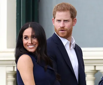 "Smiling couple in formal attire standing outside a building."