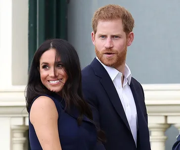 "Smiling couple in formal attire standing outside a building."