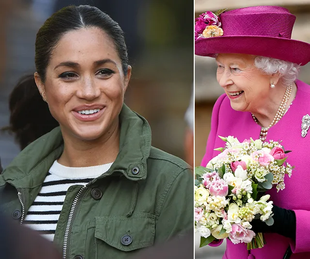 Two women smiling; one in a jacket, the other in a bright outfit holding flowers.