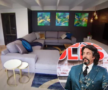 Living room with gray sectional sofa, colorful abstract wall art, and inset of a man in a blue suit.