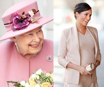 Two women smiling, one in a pink hat holding flowers, the other in a beige outfit holding a clutch.