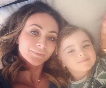 Two individuals lying together, one adult and one child, looking at the camera with relaxed expressions.